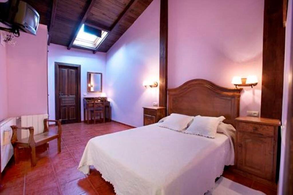 1 dormitorio con 1 cama blanca grande en una habitación en CASA RURAL LOS PORTALES Valle del Jerte, en Cabezuela del Valle