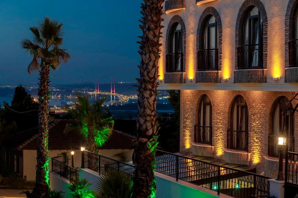 uma vista para um hotel à noite com palmeiras em LAGUN CASTLE HOTEL&SPA em Yalova