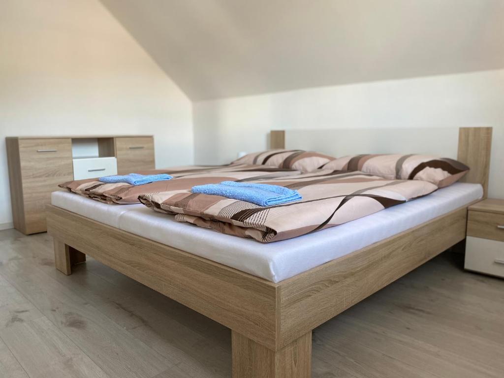 1 dormitorio con 1 cama grande con marco de madera en Penzión u Komu, en Žaškov