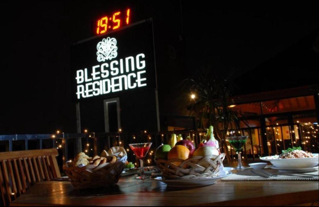 una mesa con tazones de comida y copas de vino en BLESSING RESIDENCE HOTEL, en Yakarta