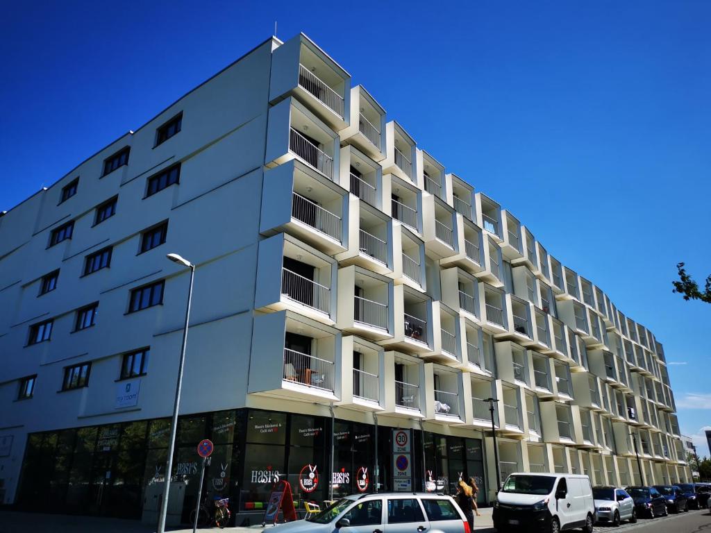 a large white building with cars parked in front of it at Top-Apartment a.d. Messe in Munich