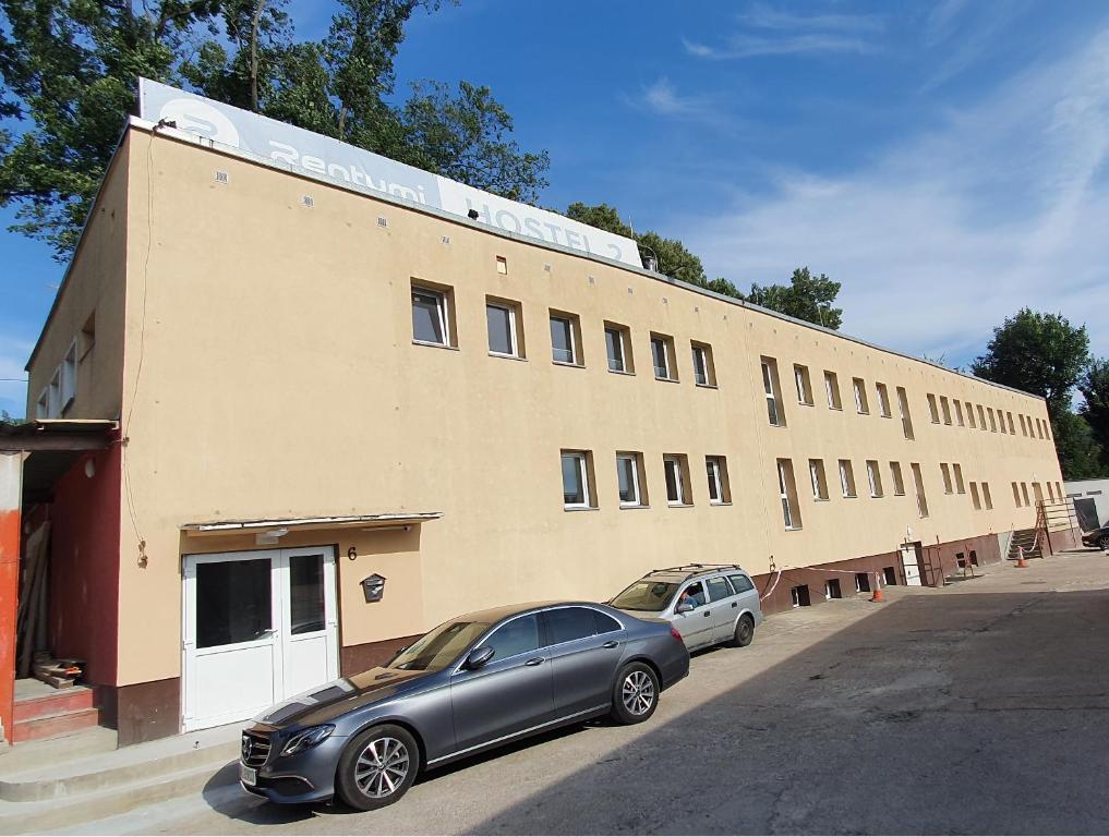 dwa samochody zaparkowane przed budynkiem w obiekcie Rentumi Hostel Gryfino-Noclegi Turystyczne i Pracownicze w mieście Gryfino