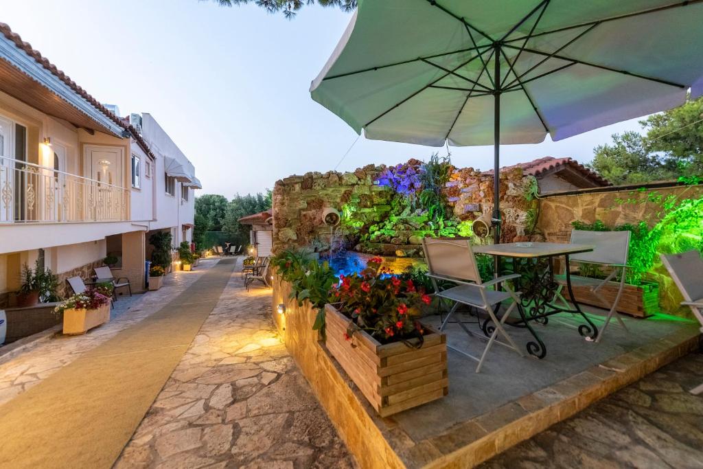 een patio met een tafel en een parasol bij Apartments Tina FREE transfer from-to the airport in Spáta