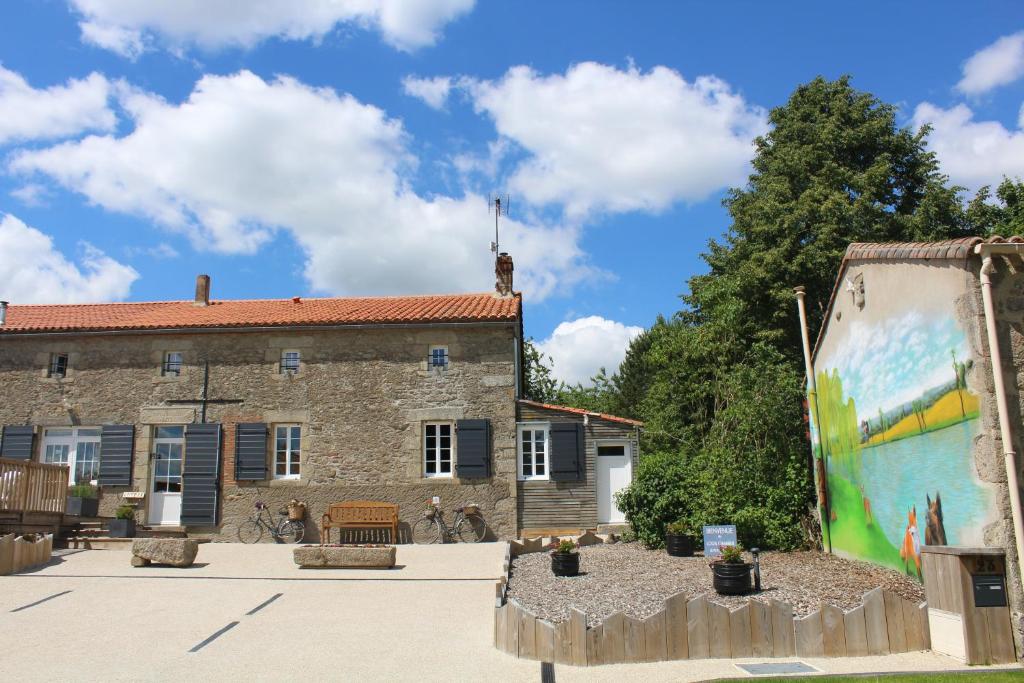 un bâtiment avec une fresque sur son côté dans l'établissement Chambres d'hôtes Logis Charrier Le Petit Bignon, aux Épesses