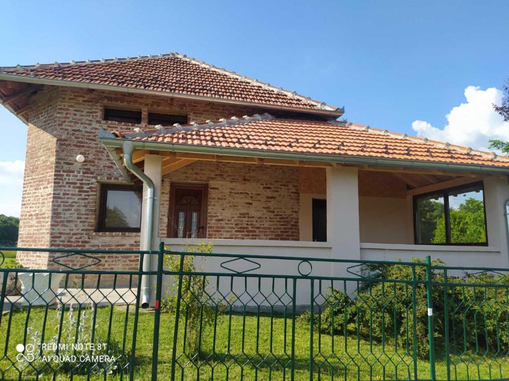 une petite maison avec une clôture devant elle dans l'établissement Vikendica Matić, à Goč