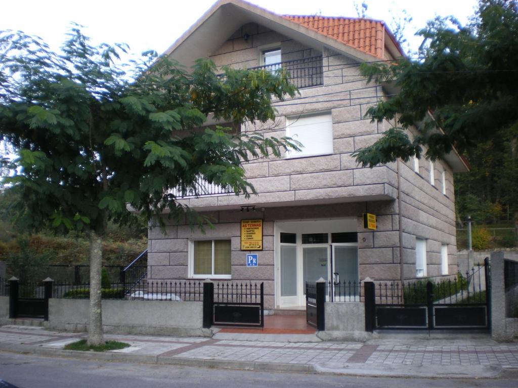 a building with a tree in front of it at PR As Termas in Bubaces