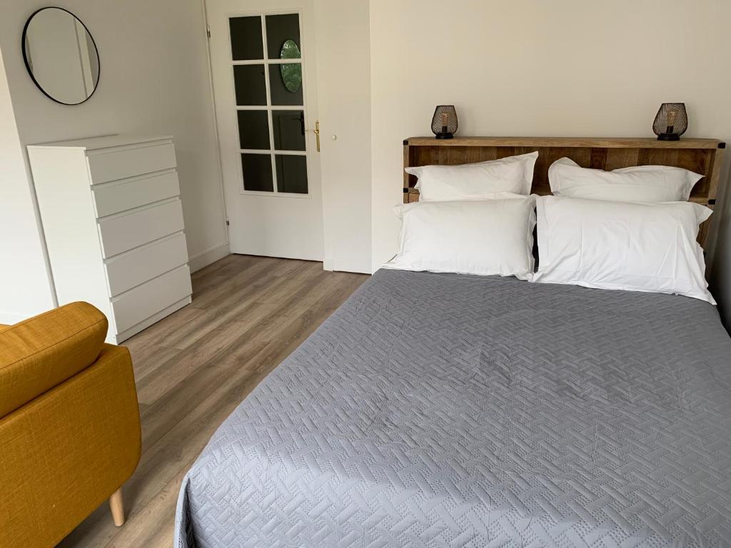 1 dormitorio con 1 cama grande con almohadas blancas en Beautiful studio located south of Paris, en Bourg-la-Reine