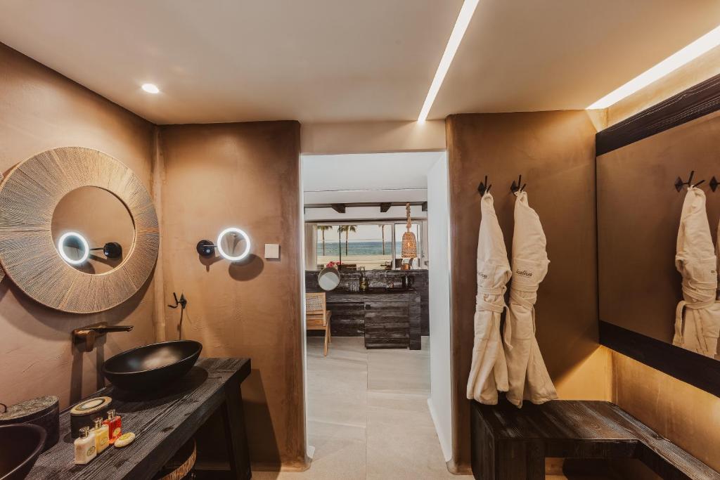 a bathroom with a sink and a mirror at Kaliva Suites - Adults Only in Ayia Napa