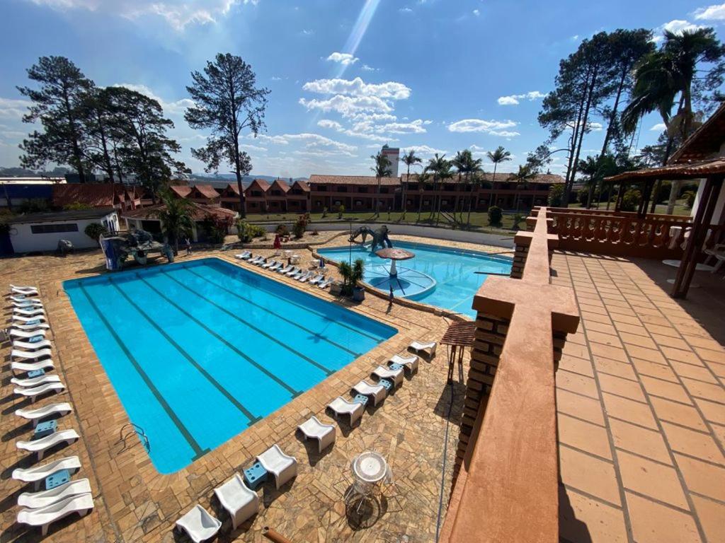 a pool at a resort with lounge chairs at Eduardos Park Hotel in Cotia