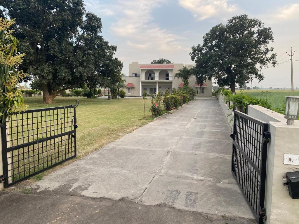 a driveway leading to a house with a fence at Mango Grove Farm in Qādiān