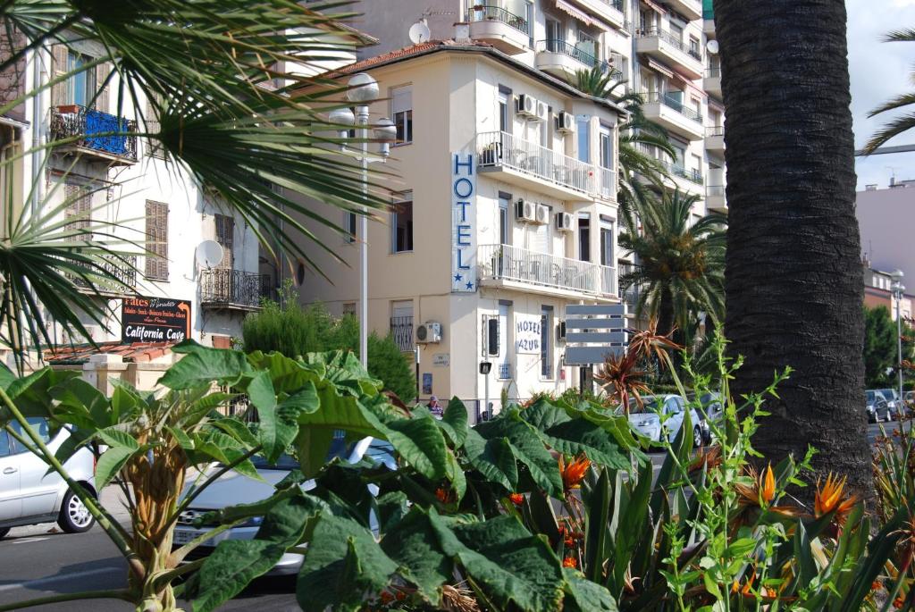 budynek z mnóstwem roślin przed nim w obiekcie Hôtel Azur w Nicei
