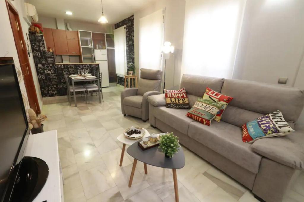 uma sala de estar com um sofá e uma mesa em Apartamento Cristo de Burgos - Kainga Homes em Sevilha