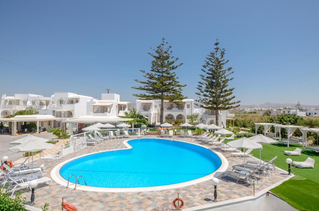 a large swimming pool in front of a villa at Birikos Studios & Apartments in Agios Prokopios