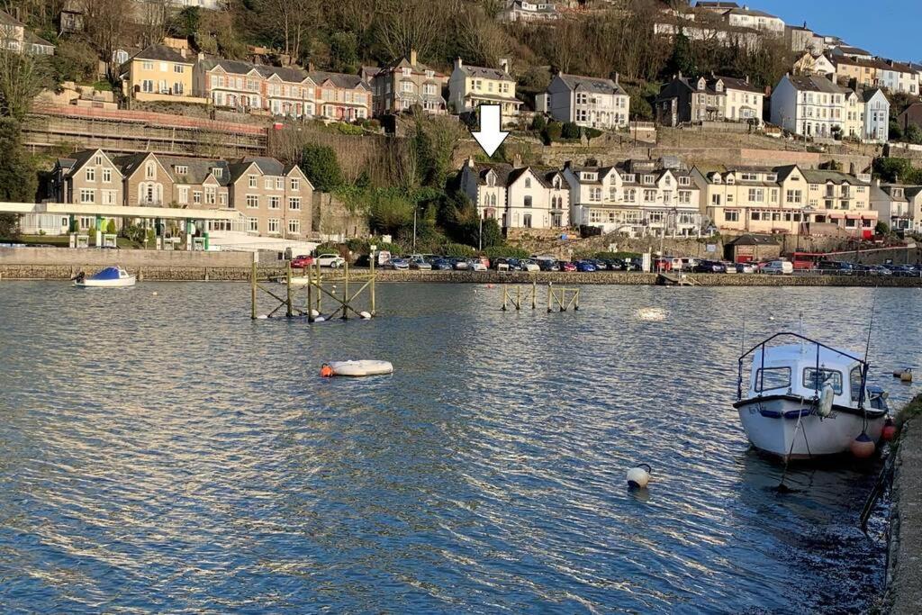 a boat is docked in the water in a city at Modern House in Looe, Near Beach and Bars with Great Views and free access to a nearby Indoor Swimming Pool in Looe