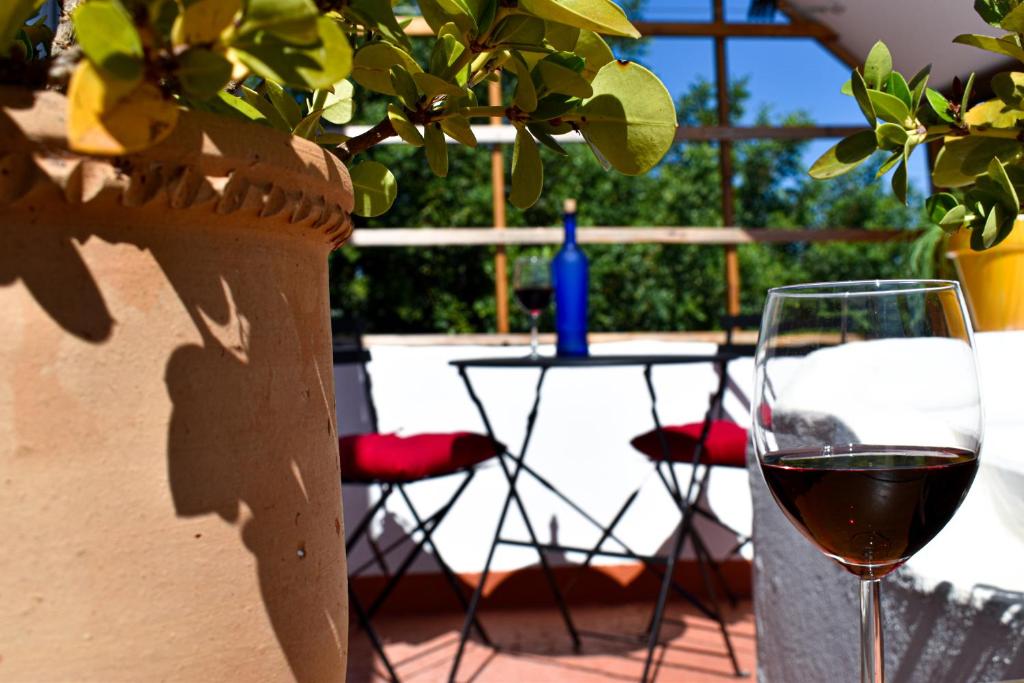 a glass of wine sitting next to a table at Heaven's Edge in São Brás de Alportel