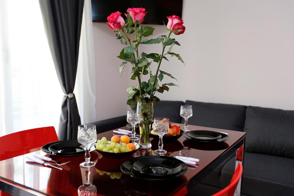 a dining room table with a vase with roses on it at Deluxe 2 Studios City Center in Burgas City