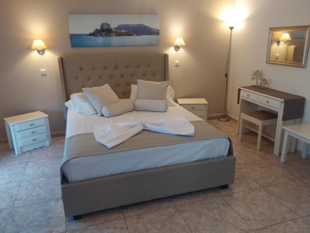 a bedroom with a large bed and a desk at Villa Soula Kaliva in Kefalos