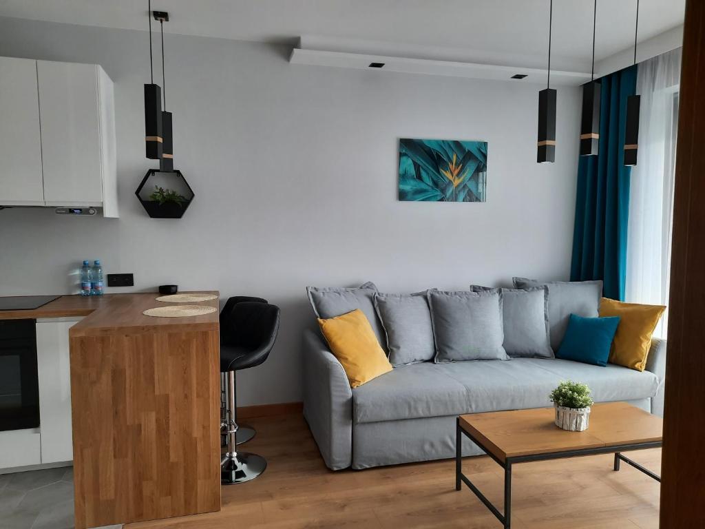 a living room with a couch and a table at APARTAMENT DĄBSKA 24 TAURON ARENA in Krakow