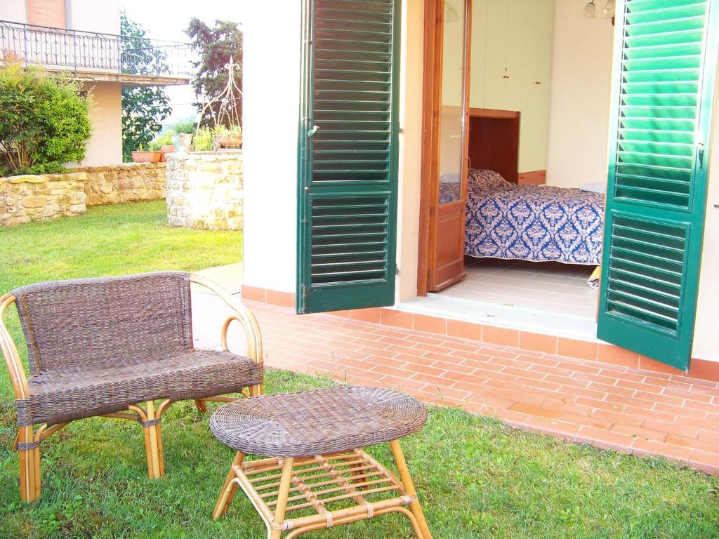 un paio di sedie e un tavolo nell'erba di Appartamenti Il Girasole a Greve in Chianti