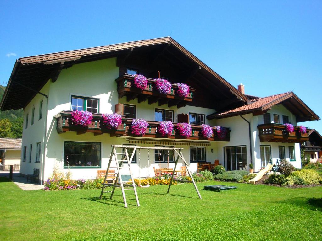 ein Haus mit Blumenkästen und Leitern im Hof in der Unterkunft Gästehaus Pilz Schladming in Schladming