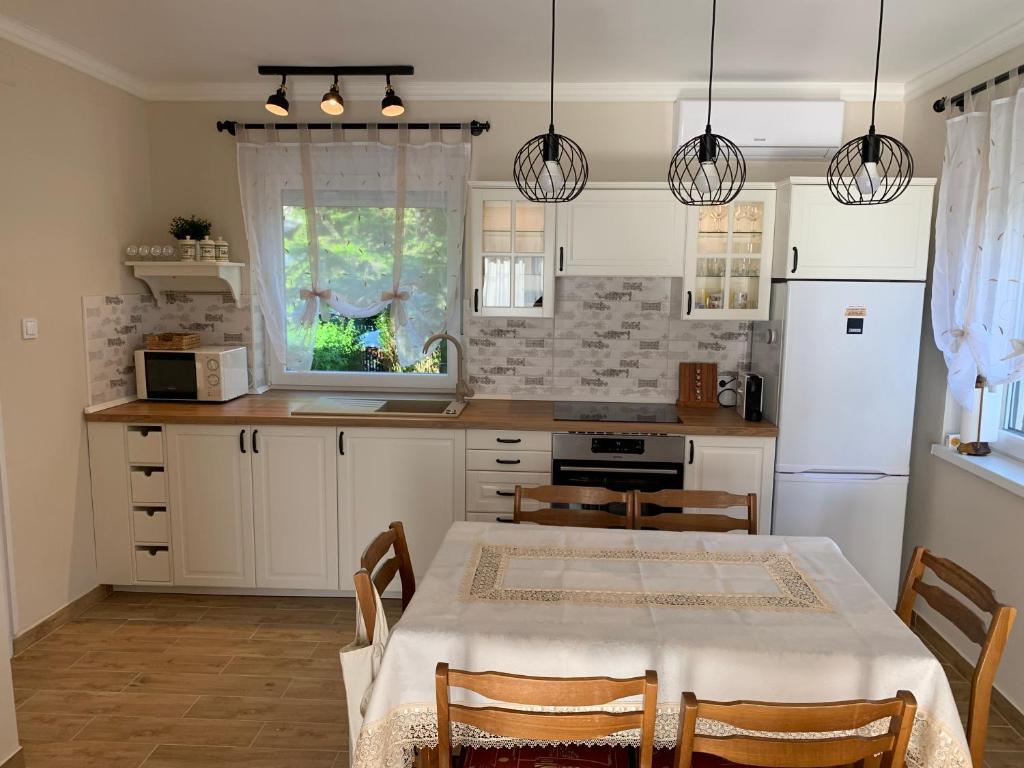 a kitchen with a table and a kitchen with white cabinets at Erika Apartmanház in Dombóvár