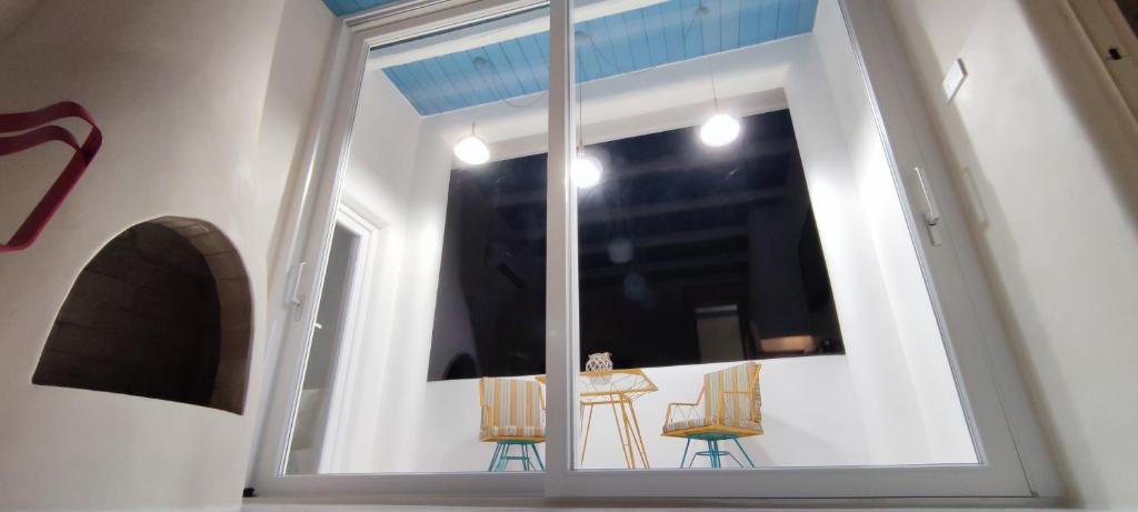 a room with a window with two chairs and a table at Casa Mediterranea Jacuzzi riscaldata con Caminetto in Specchiolla
