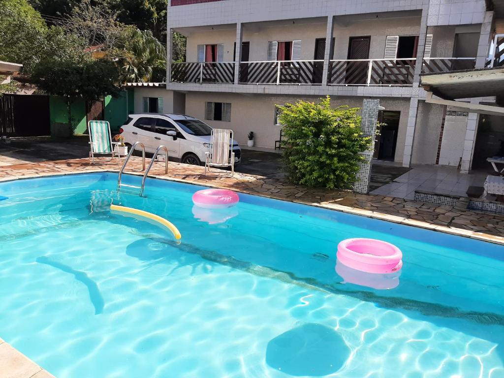 une piscine avec toboggan en face d'un bâtiment dans l'établissement Pisco Chalés, à Ubatuba