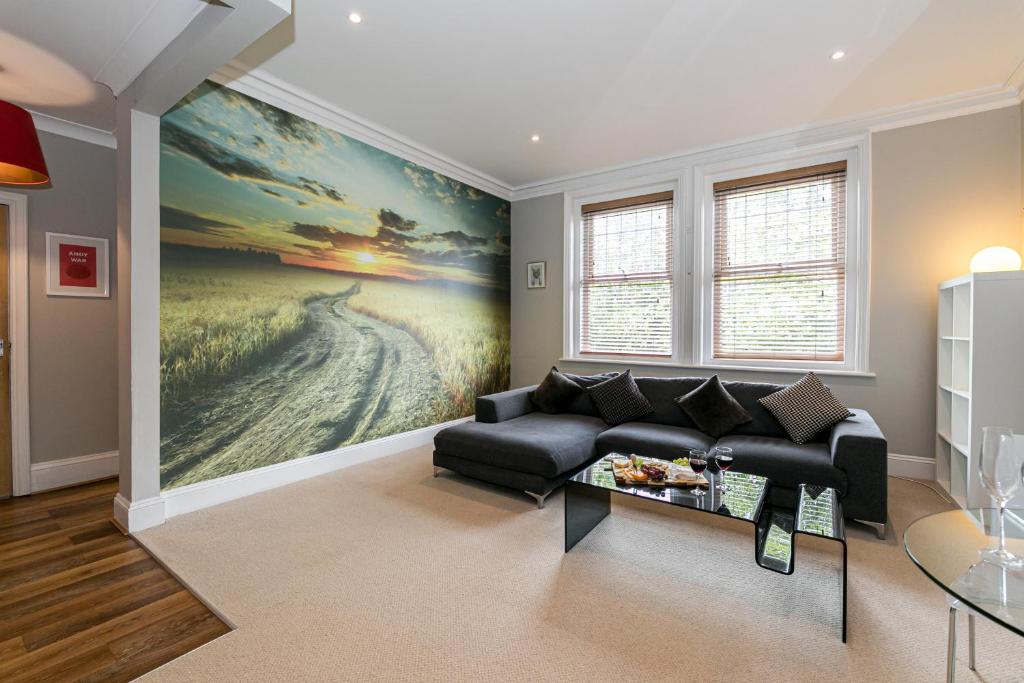 een woonkamer met een bank en een schilderij aan de muur bij Cosy Urban Oasis - Quirky 2-Bed Town Centre Apartment in Bournemouth