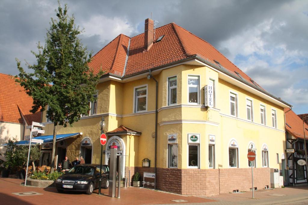 une maison jaune avec un toit rouge dans une rue dans l'établissement Deutsches Haus, à Springe