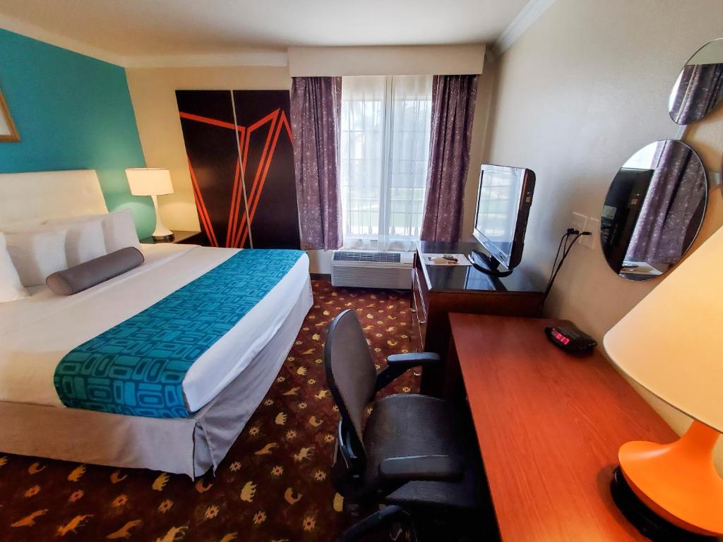 une chambre d'hôtel avec un lit et une télévision dans l'établissement Howard Johnson by Wyndham Pasadena, à Pasadena