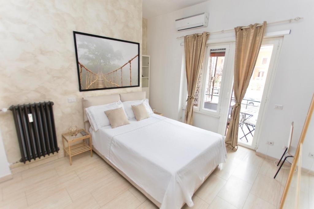 a bedroom with a white bed and a bridge painting on the wall at San Pietro Home in Rome