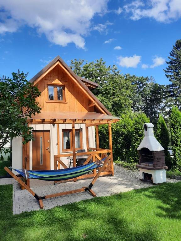 a house with a hammock in front of it at Domek Antonówka in Szklarska Poręba