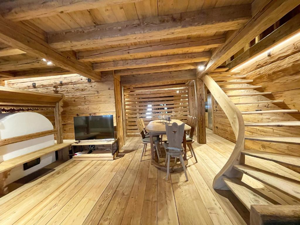 a dining room with a table and a television at Luxury Cortina in Cortina dʼAmpezzo