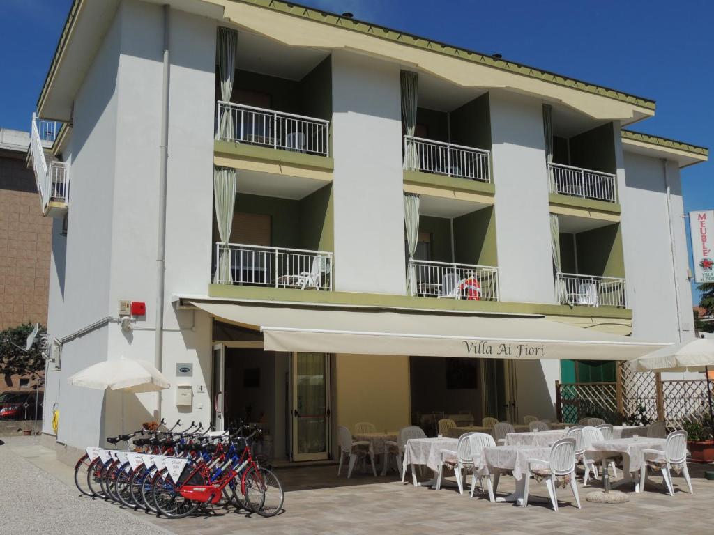 un edificio con mesas, sillas y bicicletas delante en Hotel ai Fiori, en Grado