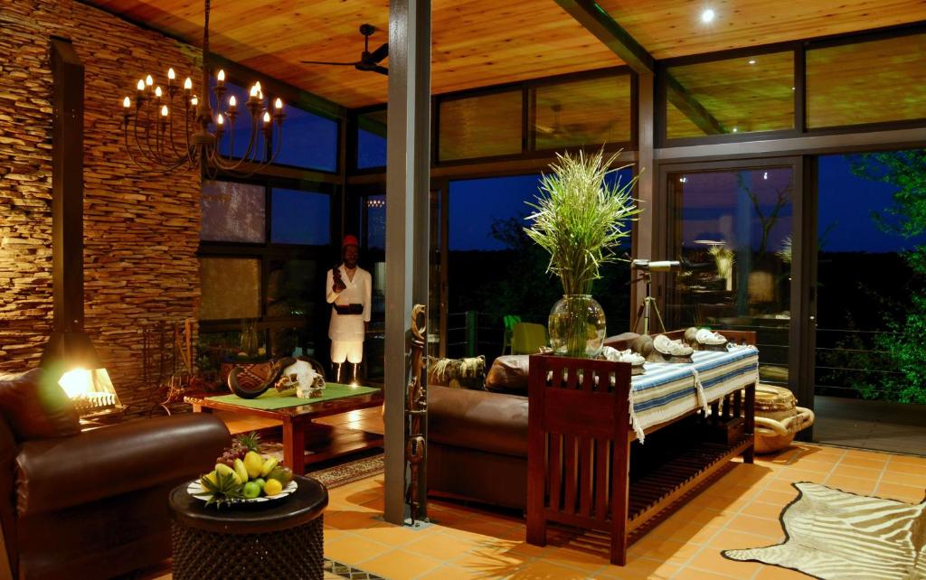 a woman is standing in a living room at Greenfire Game Lodge in Balule Game Reserve