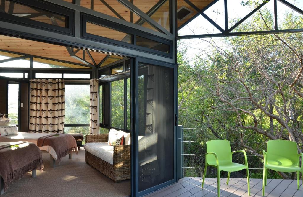 a glass house with a view of a bedroom at Greenfire Game Lodge in Balule Game Reserve