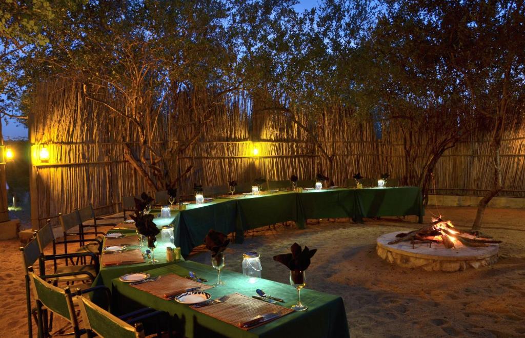 a group of tables with candles and a fire pit at Greenfire Game Lodge in Balule Game Reserve