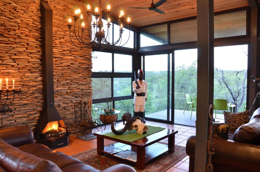 a woman standing in a living room with a dog on a table at Greenfire Game Lodge in Balule Game Reserve