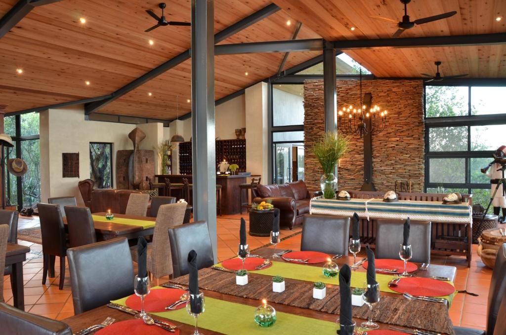 a dining room with tables and chairs in a house at Greenfire Game Lodge in Balule Game Reserve