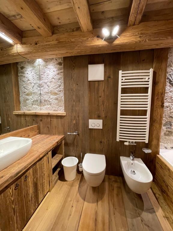 a wooden bathroom with a sink and a toilet at Luxury Cortina in Cortina dʼAmpezzo