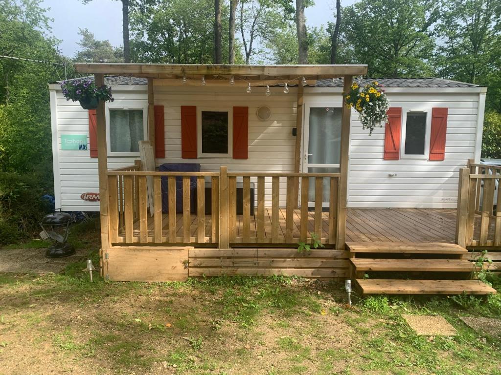 une petite maison avec un porche et une terrasse dans l'établissement mobil home, à Saint-Chéron