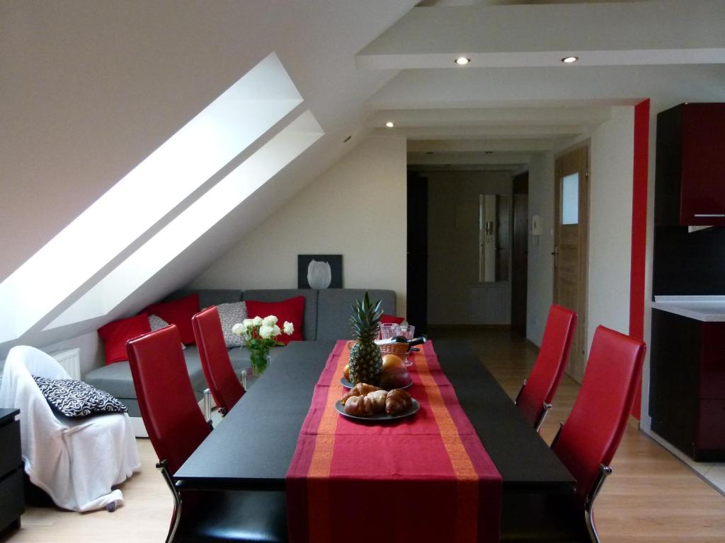 comedor con mesa negra y sillas rojas en Apartament BB koło Cerkwi, en Krynica-Zdrój
