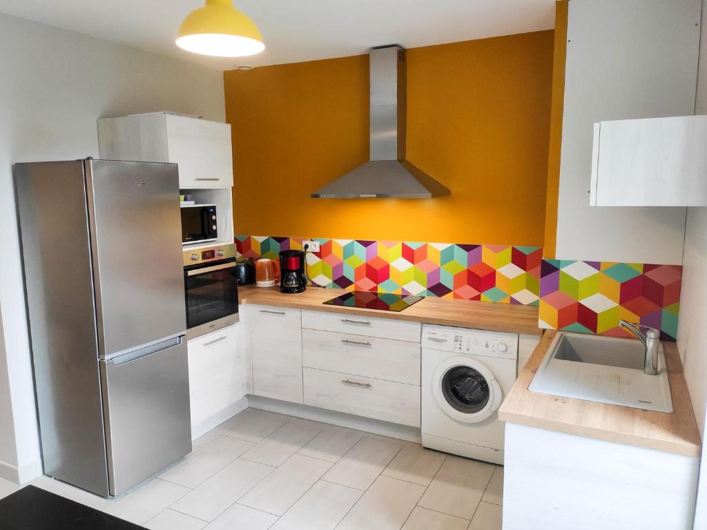 uma cozinha com um frigorífico de aço inoxidável e uma máquina de lavar louça em Le Puy Carmin - Gîte 6 personnes - 18 min du PuyDuFou em Bazoges-en-Paillers
