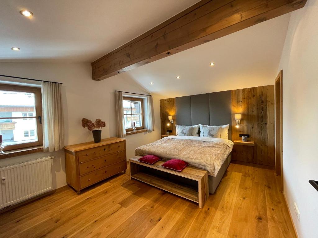 a bedroom with a large bed and a wooden floor at Sonnenschein Appartement Rebecca in Kirchberg in Tirol
