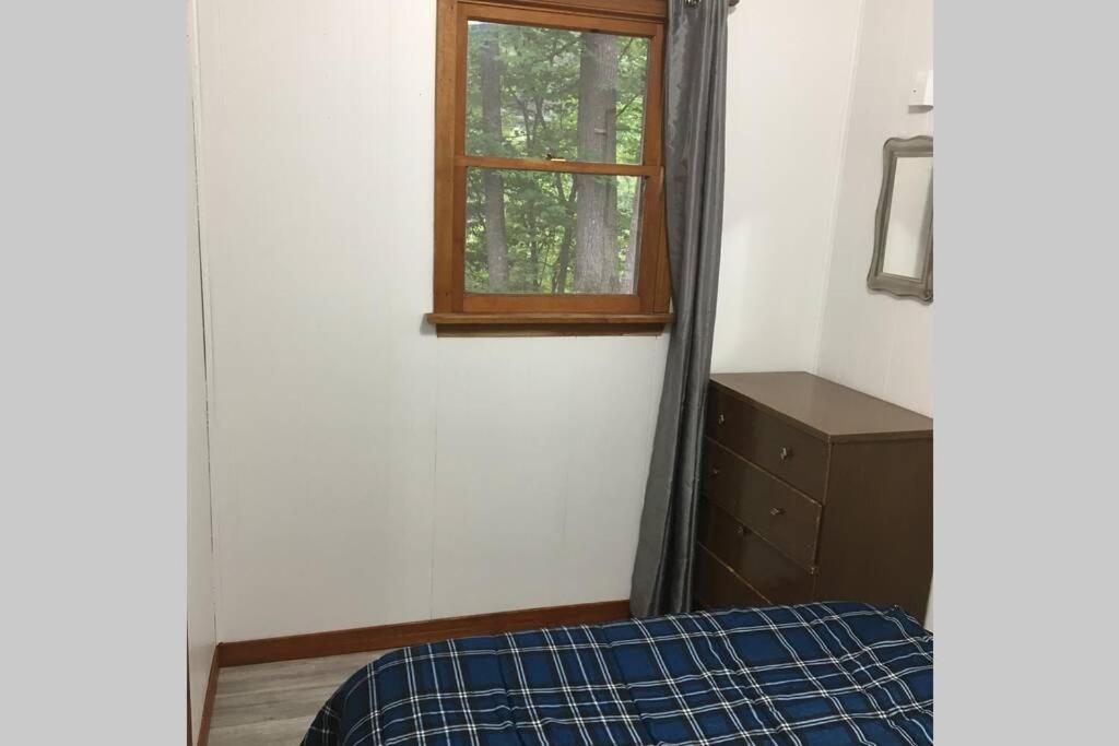 a bedroom with a bed and a window at Riverfront Rustic Cottage in Durham Bridge