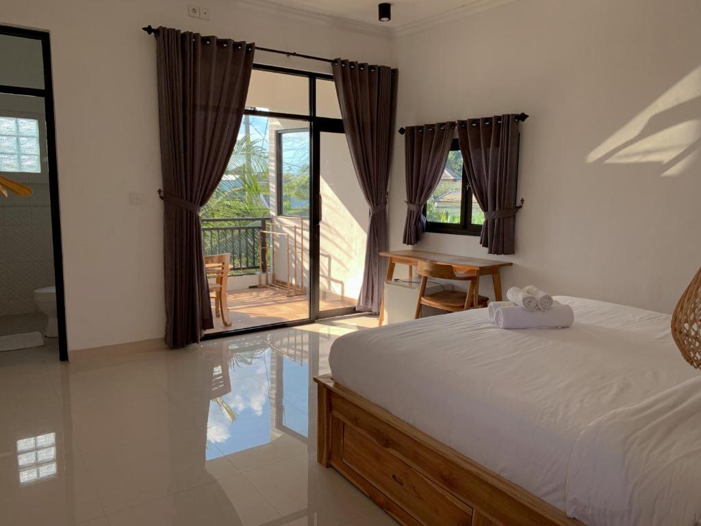 1 dormitorio con 1 cama y puerta corredera de cristal en Kenan Cottage, en Canggu