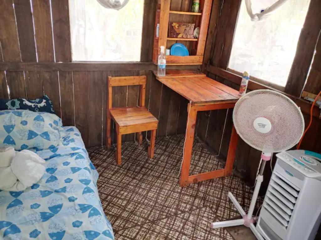 Habitación con escritorio, cama y mesa. en Sustainable Cabain en Cozumel