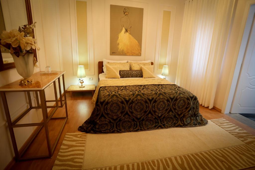a bedroom with a bed and two tables with lamps at Vila Essel in Korçë