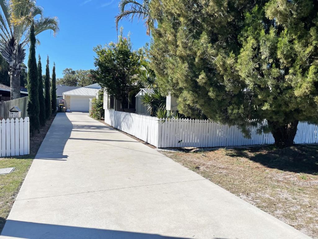 a sidewalk in front of a white fence at Bribie Beach Bungalow in Bongaree