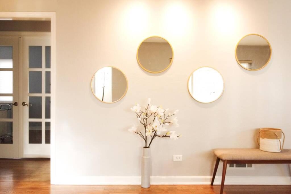 uma parede branca com três espelhos e um vaso com flores em Family-Friendly Mid-century Modern Retreat em Denver